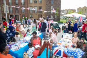 People at a street party with Union Flag bunting and table cloths